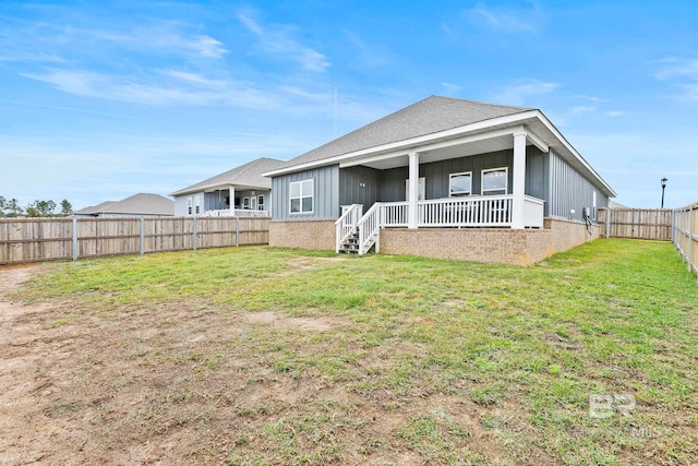 rear view of property with a yard