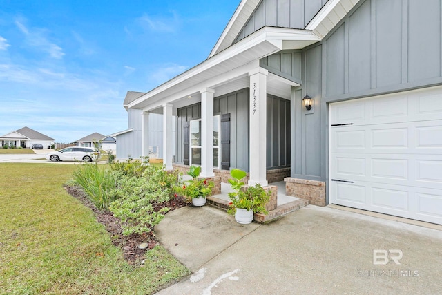 property entrance featuring a lawn and covered porch