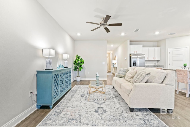 living room featuring hardwood / wood-style floors and ceiling fan