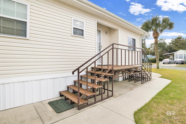 view of exterior entry featuring a patio and a yard