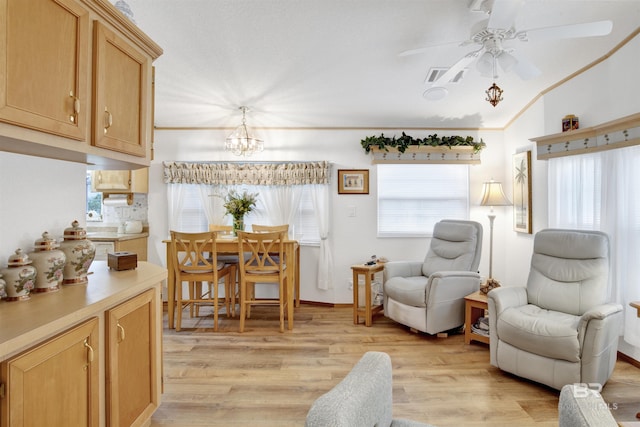 sitting room with ceiling fan with notable chandelier, light wood-type flooring, and crown molding