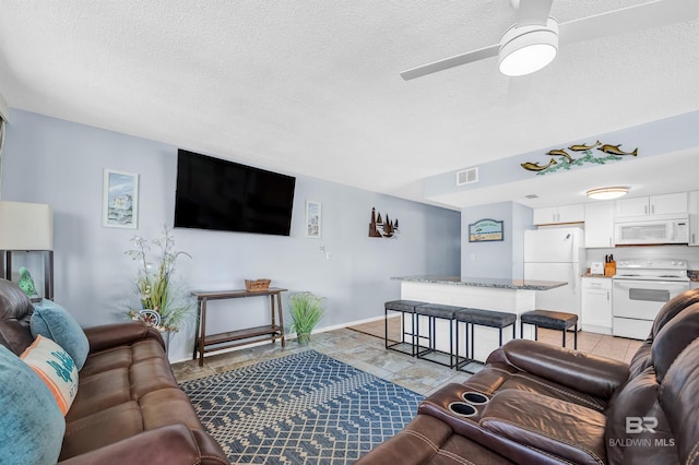 407 W Beach Blvd Unit 570, Gulf Shores, AL 36542 - living area with a textured ceiling, ceiling fan, and baseboards