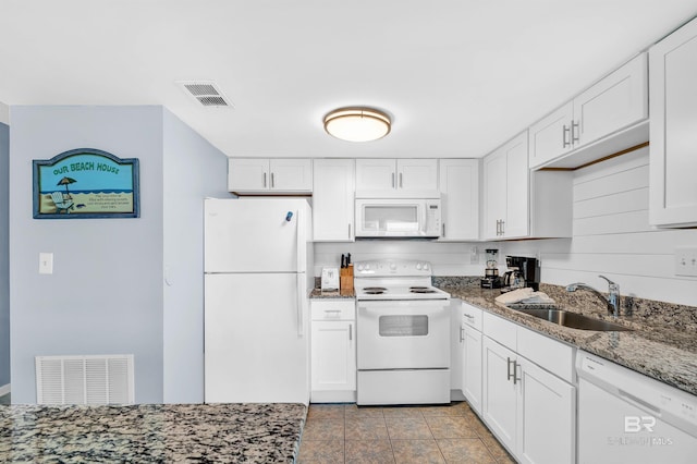 407 W Beach Blvd Unit 570, Gulf Shores, AL 36542 - kitchen featuring white appliances, a sink, white cabinets, and dark stone counters