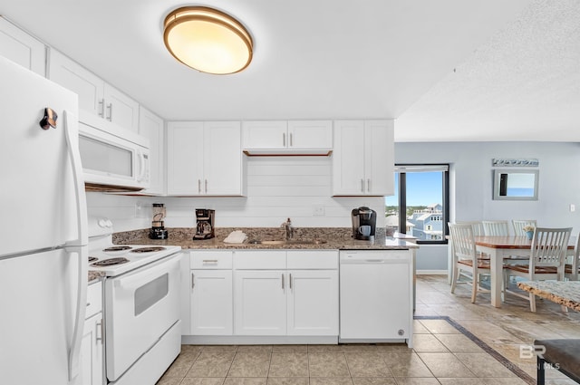407 W Beach Blvd Unit 570, Gulf Shores, AL 36542 - kitchen with white appliances, a sink, white cabinets, and dark stone counters
