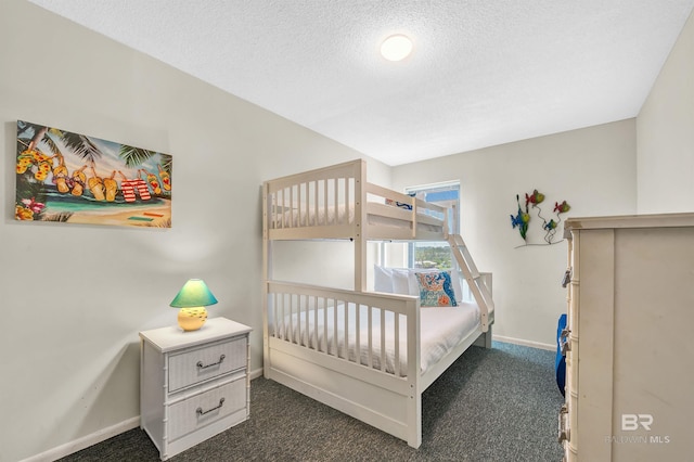 407 W Beach Blvd Unit 570, Gulf Shores, AL 36542 - bedroom featuring dark carpet, baseboards, and a textured ceiling