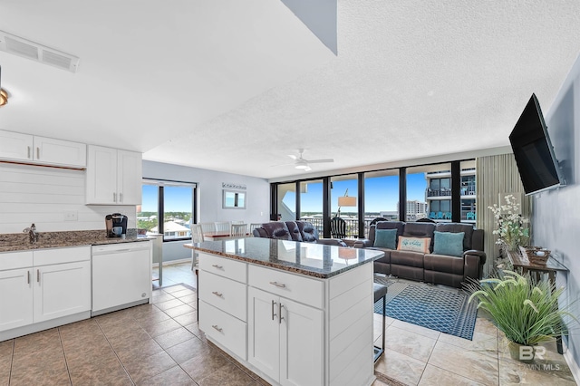 407 W Beach Blvd Unit 570, Gulf Shores, AL 36542 - kitchen with dishwasher, a ceiling fan, dark stone counters, open floor plan, and a textured ceiling