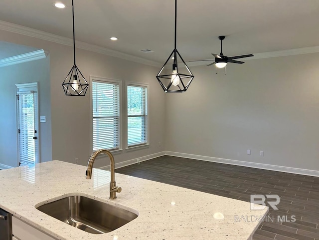 kitchen with light stone countertops, decorative light fixtures, and sink