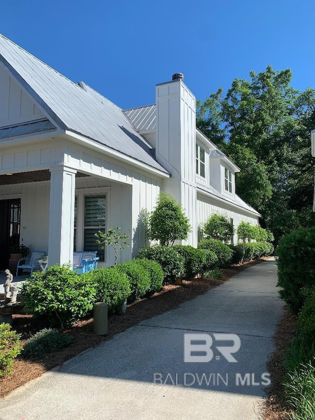40 Bay Pointe Ct, Fairhope, AL 36532 - view of home's exterior featuring board and batten siding, a chimney, and metal roof