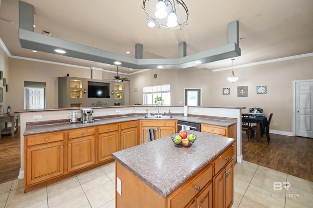 kitchen featuring ceiling fan, light tile patterned floors, sink, and a large island