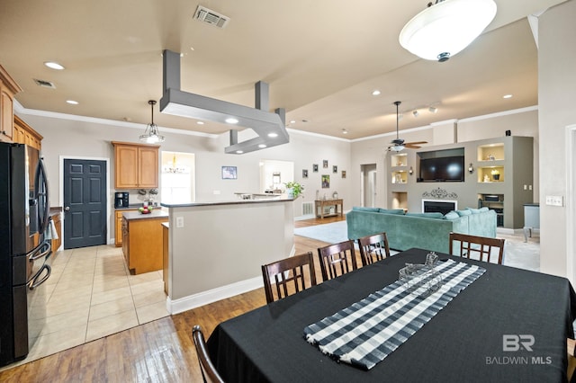 dining room featuring ceiling fan, ornamental molding, and light hardwood / wood-style floors