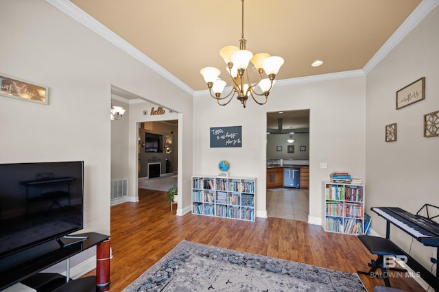 interior space with light hardwood / wood-style flooring, ornamental molding, and an inviting chandelier