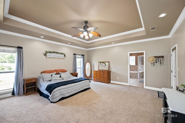 carpeted bedroom with ceiling fan, crown molding, a tray ceiling, and ensuite bathroom