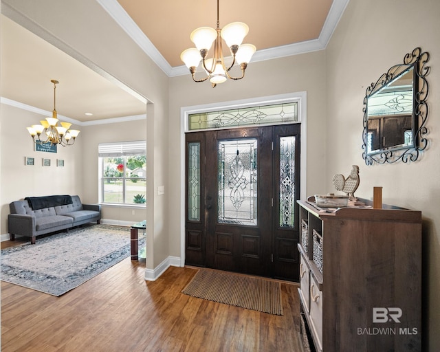 entrance foyer with a chandelier, crown molding, and hardwood / wood-style floors