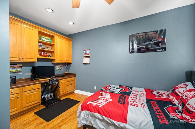 bedroom featuring light hardwood / wood-style floors, ceiling fan, and built in desk