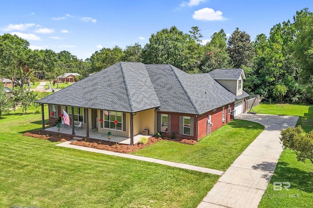 view of front of home featuring a front yard, covered porch, and a garage