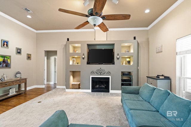 living room with dark wood-type flooring, ceiling fan, ornamental molding, and built in features