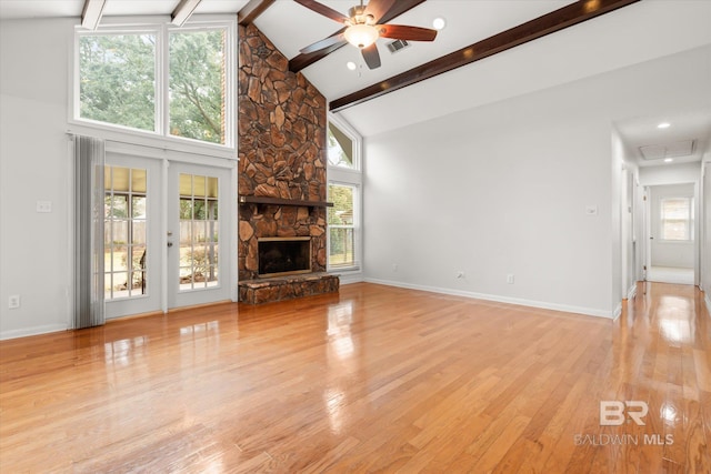 unfurnished living room with beamed ceiling, a fireplace, high vaulted ceiling, and light hardwood / wood-style flooring