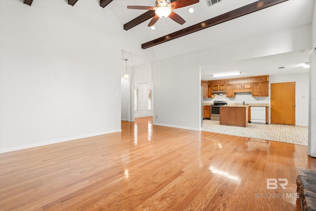 unfurnished living room with high vaulted ceiling, beamed ceiling, sink, ceiling fan, and light hardwood / wood-style flooring