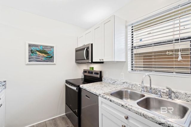 1028 W Beach Blvd Unit 4, Gulf Shores, AL 36542 - kitchen with appliances with stainless steel finishes, dark wood-style flooring, and white cabinets