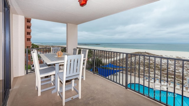 balcony featuring a view of the beach and a water view