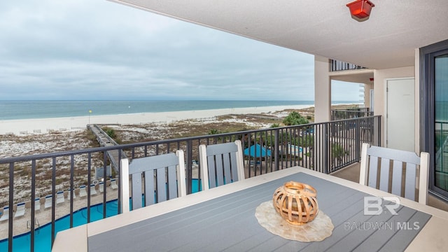 balcony featuring a water view and a view of the beach