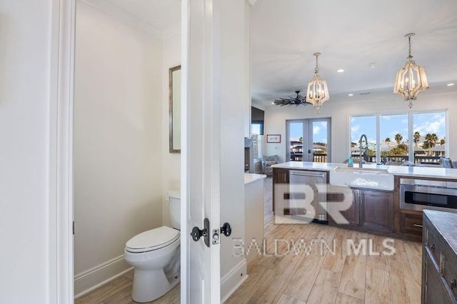 bathroom with ceiling fan, sink, french doors, wood-type flooring, and toilet