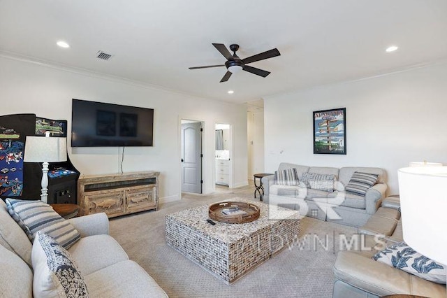 living room featuring ceiling fan, light carpet, and ornamental molding