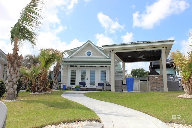 rear view of house featuring french doors, a ceiling fan, a lawn, and area for grilling