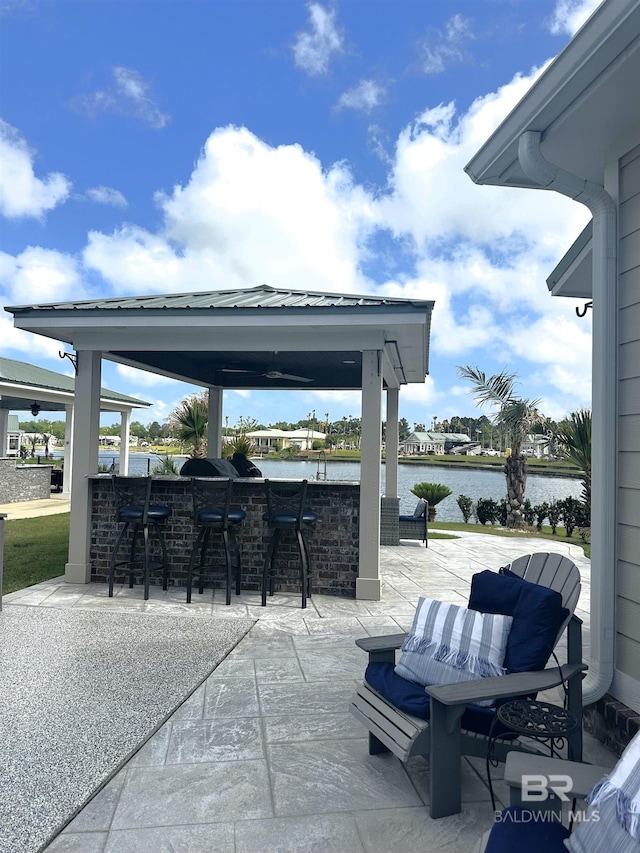 view of patio / terrace with a gazebo, outdoor dry bar, and a water view