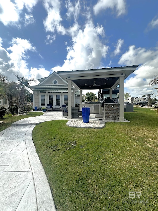 rear view of property with a yard and area for grilling