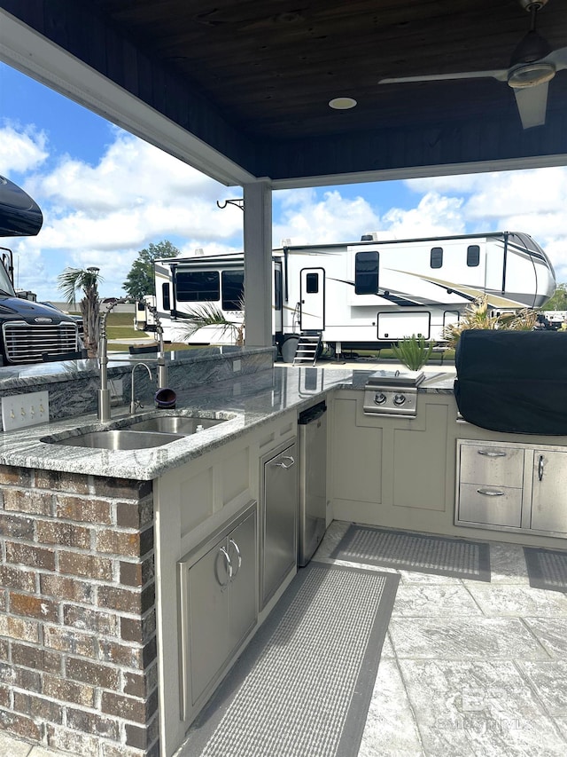 view of patio featuring an outdoor kitchen, a sink, and ceiling fan