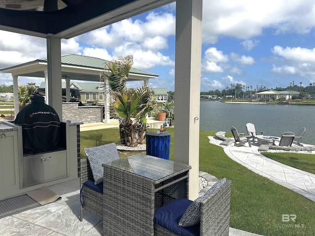 view of patio / terrace featuring a water view, a gazebo, outdoor dining space, area for grilling, and an outdoor fire pit