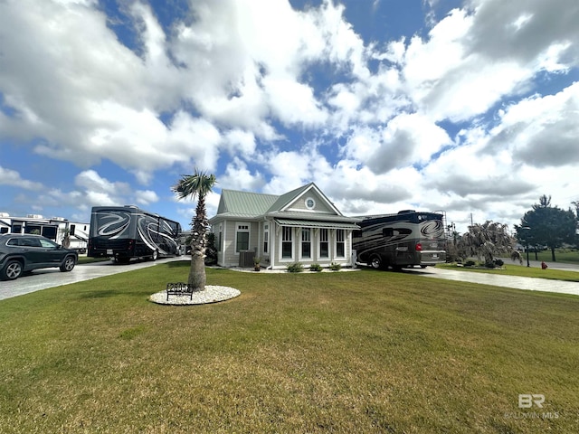 greek revival house featuring a front lawn, driveway, and metal roof