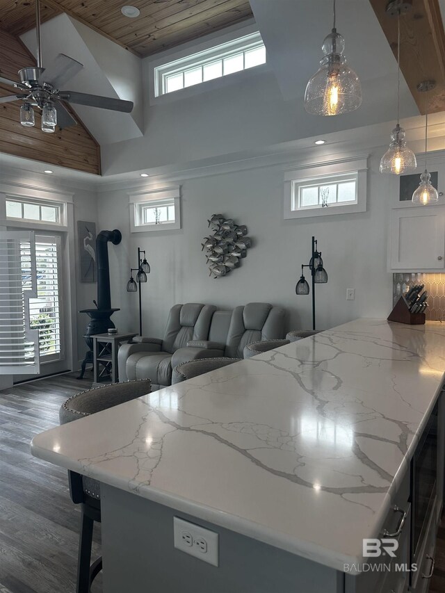 living room featuring recessed lighting, a wood stove, dark wood-type flooring, high vaulted ceiling, and ceiling fan