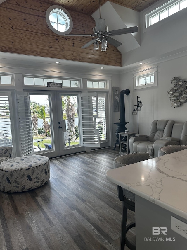 living room featuring ceiling fan, a wood stove, wooden ceiling, high vaulted ceiling, and dark wood-style flooring