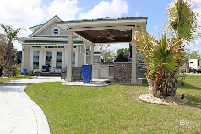 back of house featuring a ceiling fan, exterior kitchen, french doors, a patio, and a lawn