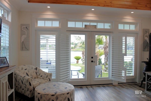 entryway with plenty of natural light, a water view, wood finished floors, and french doors