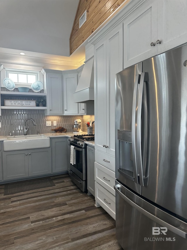 kitchen featuring stainless steel appliances, light countertops, open shelves, a sink, and premium range hood
