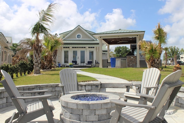 view of patio / terrace with a gazebo, french doors, a fire pit, an outdoor kitchen, and ceiling fan