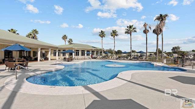 pool featuring fence and a patio area