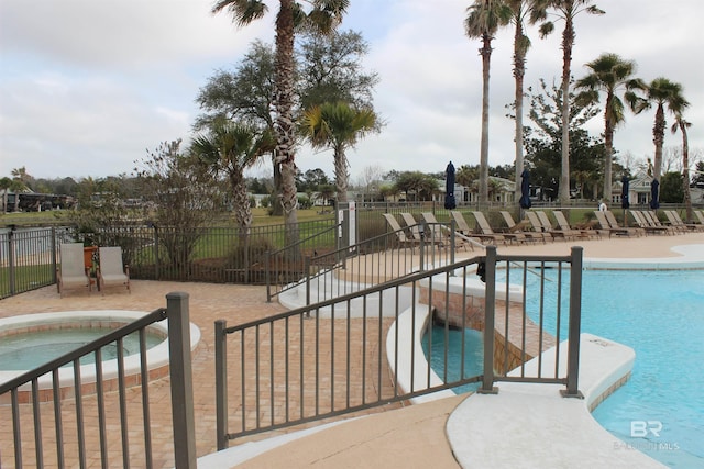 community pool featuring fence, a community hot tub, and a patio