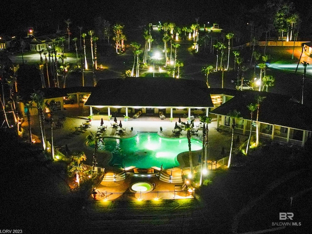 pool at twilight with a community pool and a patio