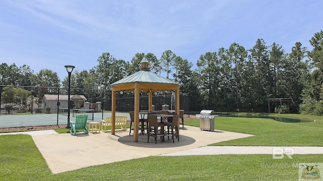 exterior space featuring a gazebo, a yard, a tennis court, and fence