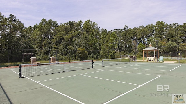 view of tennis court featuring community basketball court, fence, and a gazebo