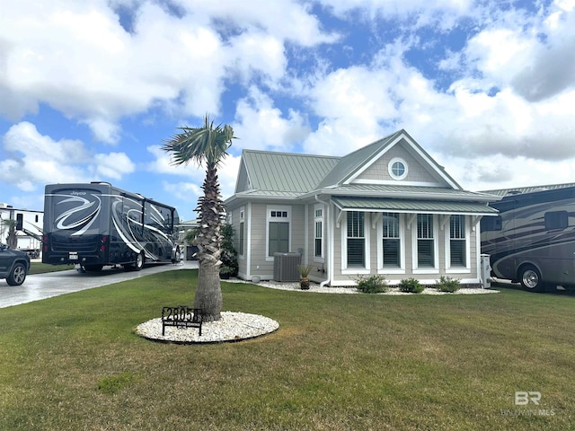 view of front of property with central air condition unit, a standing seam roof, a front lawn, and metal roof
