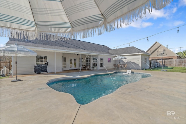 view of swimming pool featuring pool water feature, french doors, and a patio