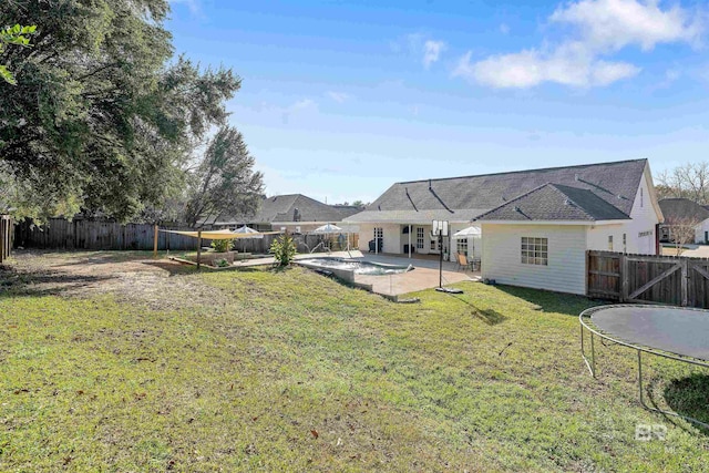 view of yard with a trampoline and a patio area