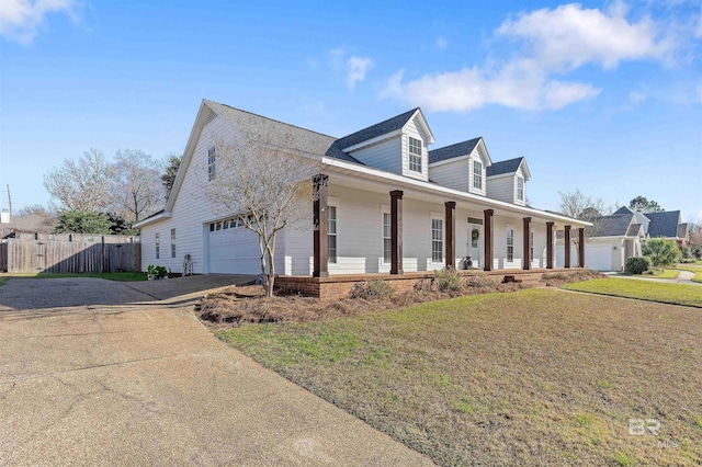 cape cod home featuring a front lawn, a porch, and a garage