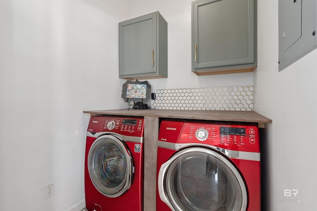 clothes washing area with cabinets, washing machine and clothes dryer, and electric panel