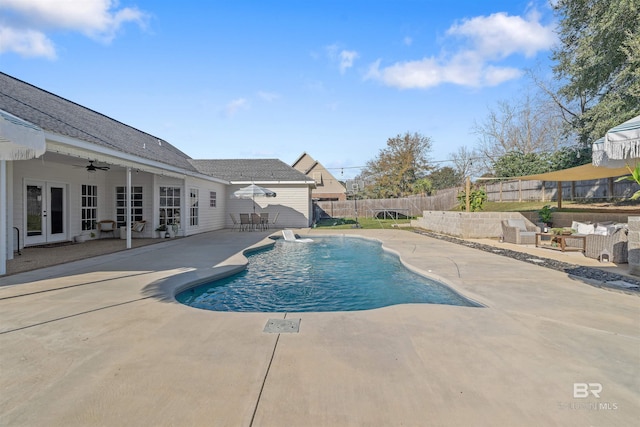 view of pool featuring ceiling fan, a patio area, outdoor lounge area, and french doors